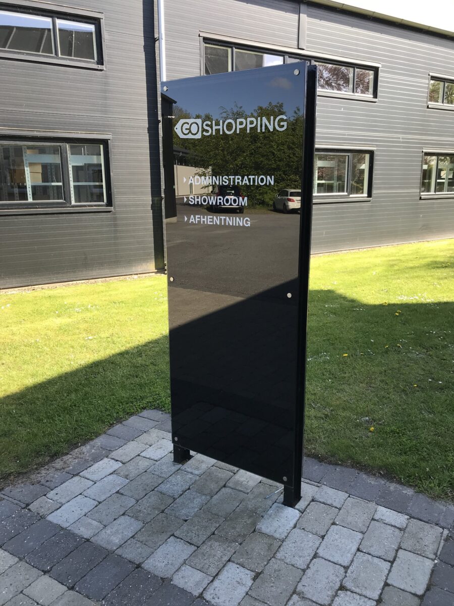Go-shopping-pylon Et rundt blåt skilt med tvmv logo på, placeret på en palle