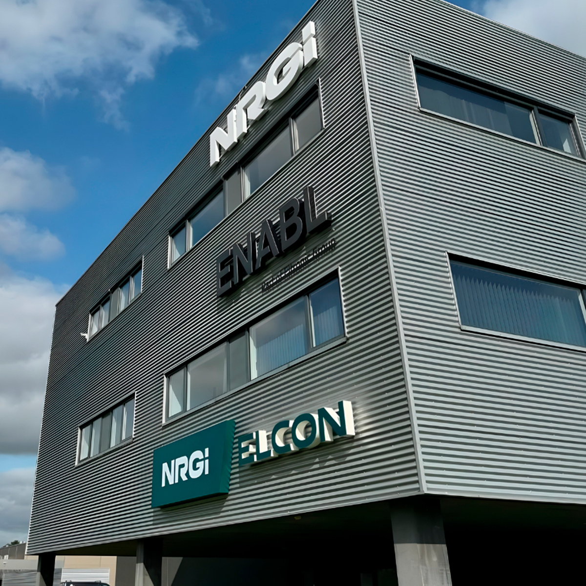 Grå facadebygning med fire facadeskilte på 