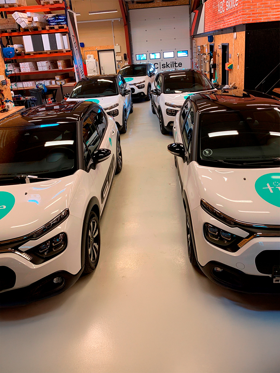 5 hvide biler med grøn logo på kølerhjelmen