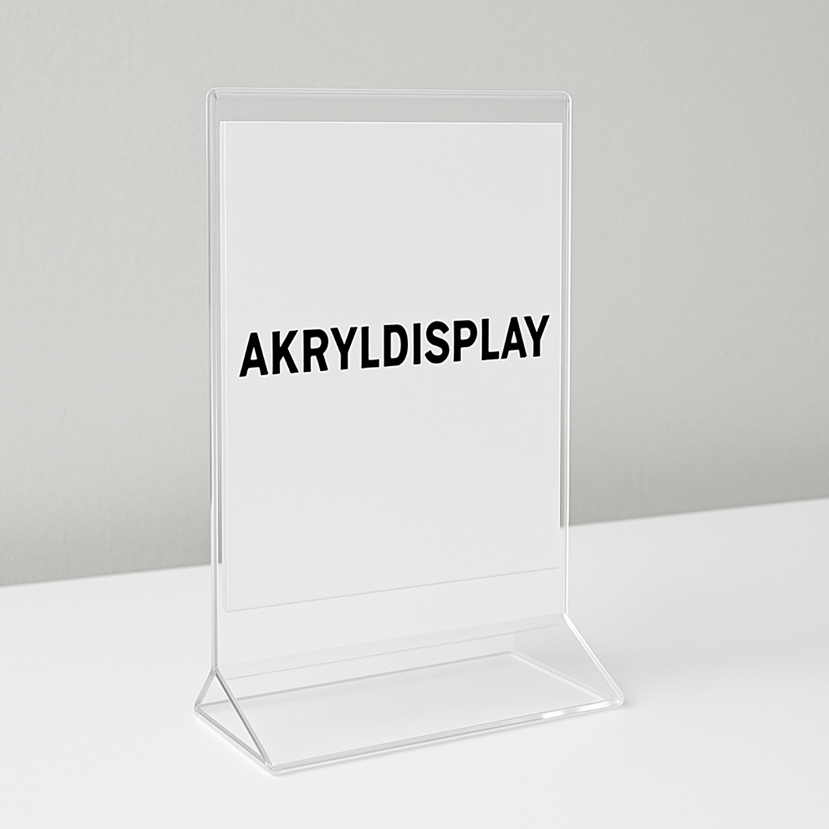 Transparent akryldisplay med lodret skilt, placeret på hvid overflade, med teksten ‘AKRYLDISPLAY’