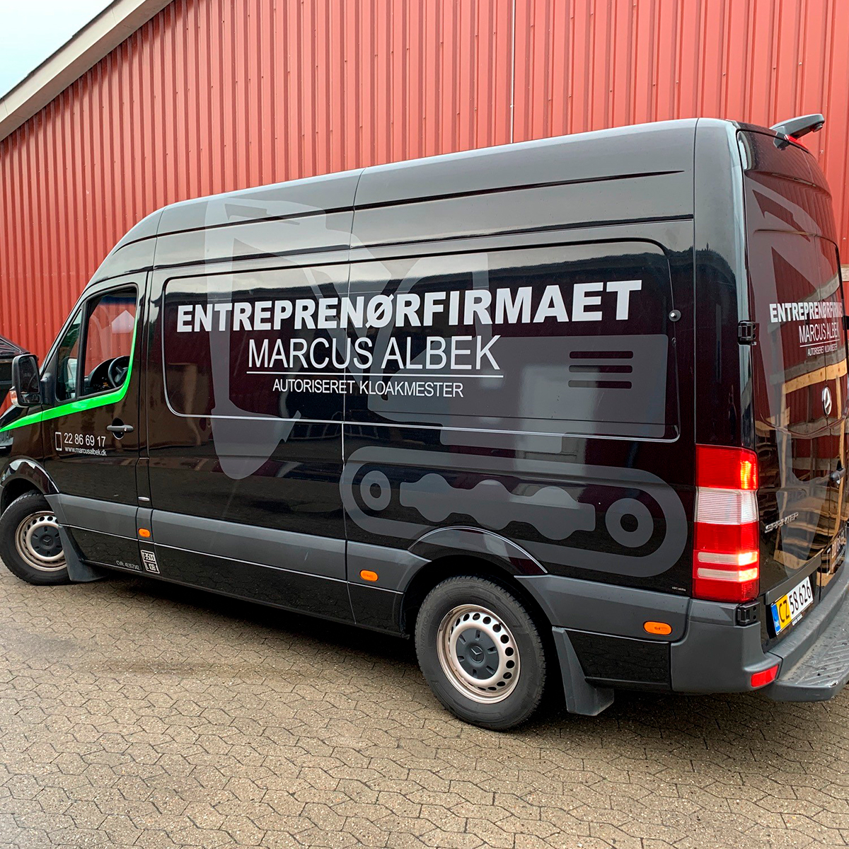 Sort arbejdsbil med gravmaskine folieret på siden i mat sort