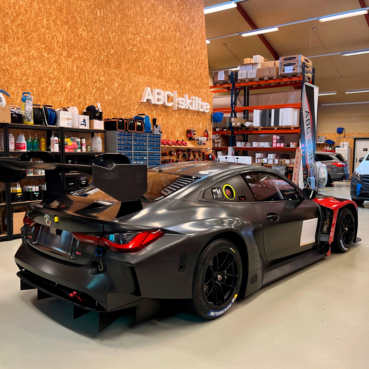 BMW bil folieret ind i sort folie stående på et værksted