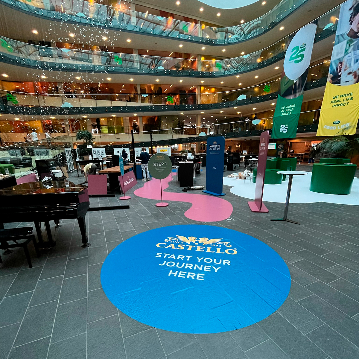 Indendørs butiks- eller eventinstallation med blå, lyserød, grøn og gule grafiske designs i et moderne miljø