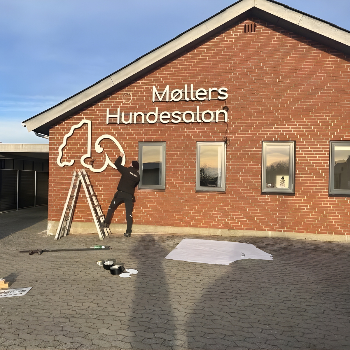 Murstenshus med facadeskilt formskåret bogstaver "Møllers hundesalon" 
