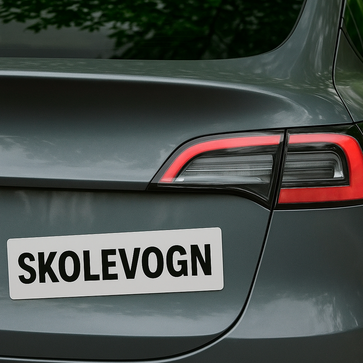 Bagside af bil med påmonteret hvidt skilt med teksten ‘Skolevogn'