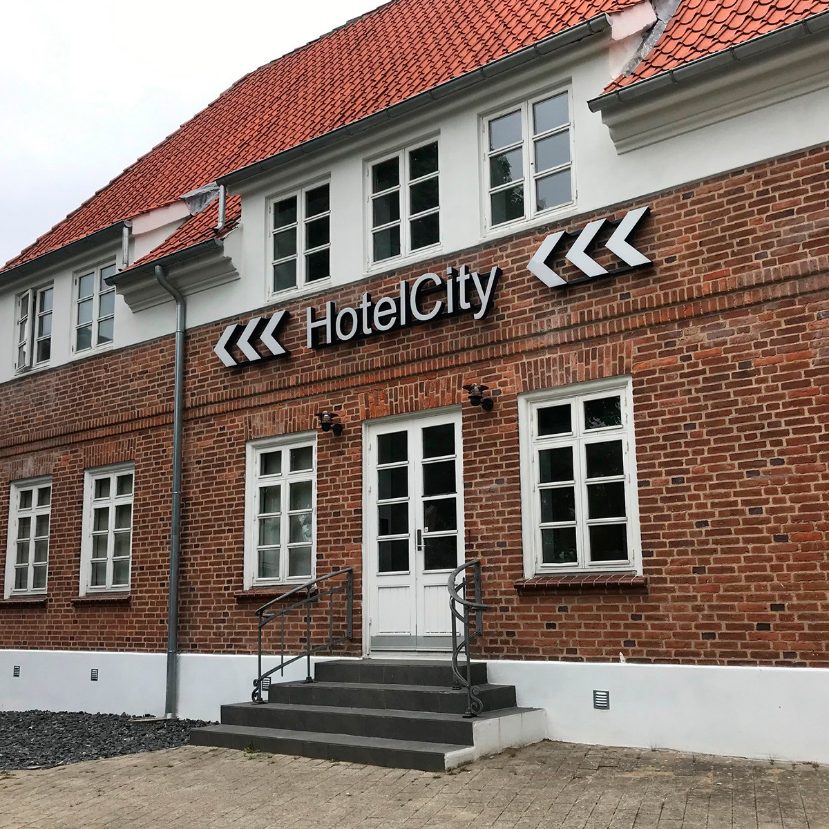 Hotel med røde muresten og LED facadeskilt "Hotel City" på facaden