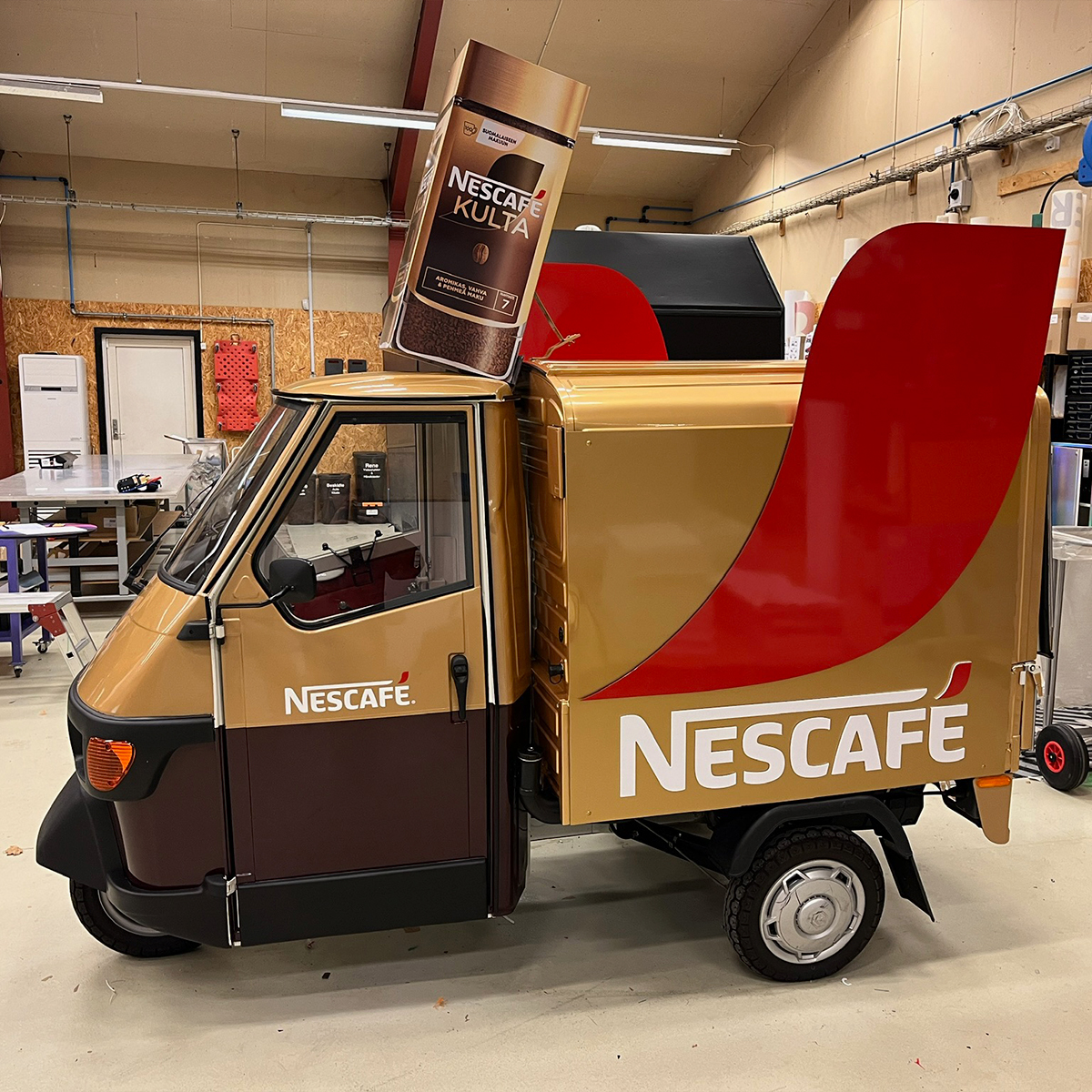 Specialbygget salgs- og eventkøretøj med Nescafé-branding, opstillet indendørs i produktionsmiljø