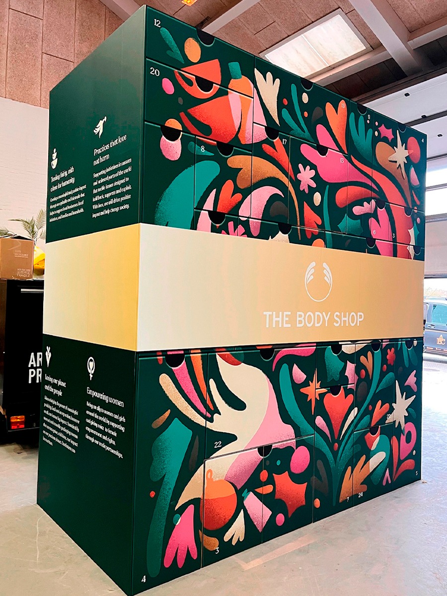 Stor udgave af en julekalende fra The Body Shop stående på et gulv