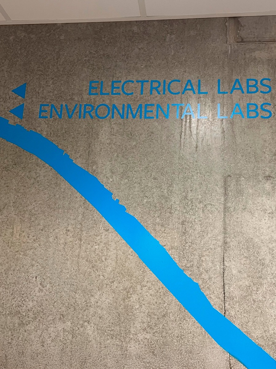 Wayfinding Betonvæg med lyseblå wayfinding på væggen